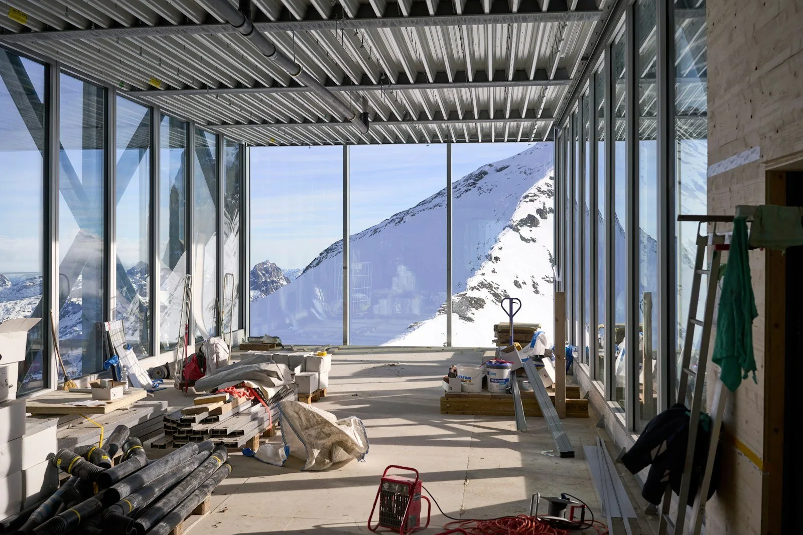 Innenraum während des Ausbaus mit Deckenprofilen und großer Glasfront